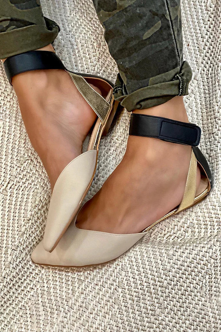 Woman wearing two-tone pointed toe flats with ankle strap