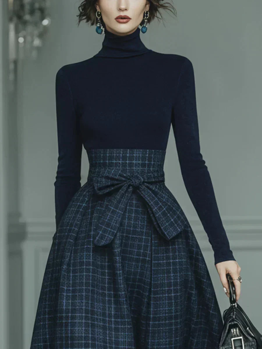 Woman wearing dark blue high-neck top and plaid skirt set