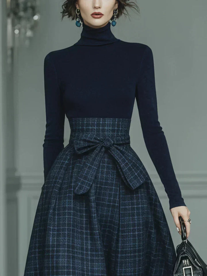 Woman wearing dark blue high-neck top and plaid skirt set