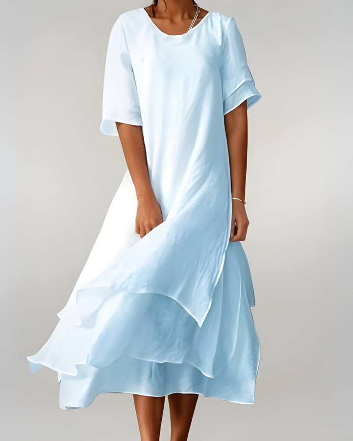 Woman wearing flowing maxi dress with open neckline