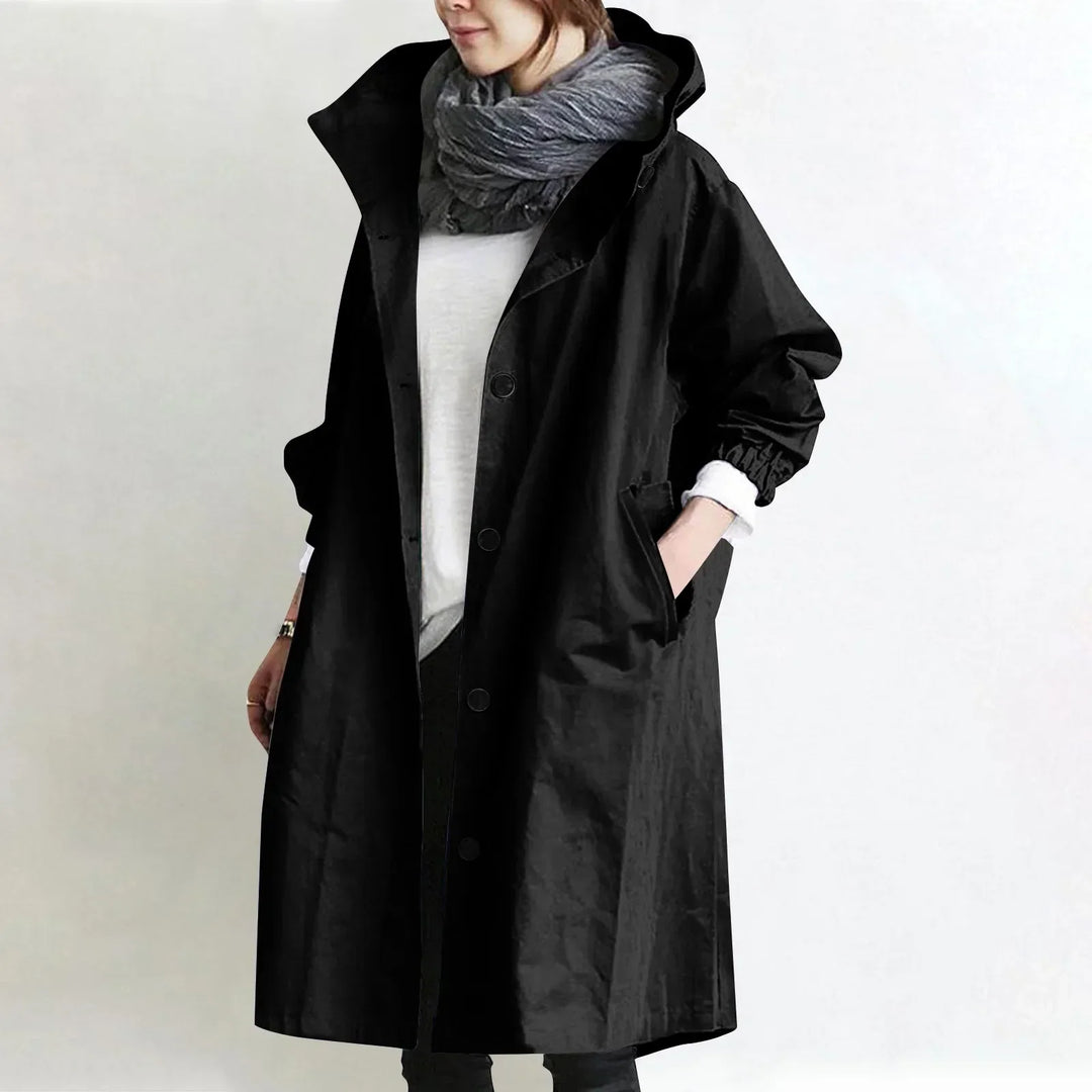 Woman wearing long hooded coat with button front