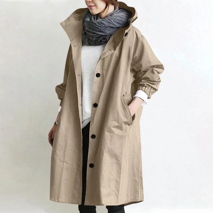 Woman wearing long hooded coat with button front